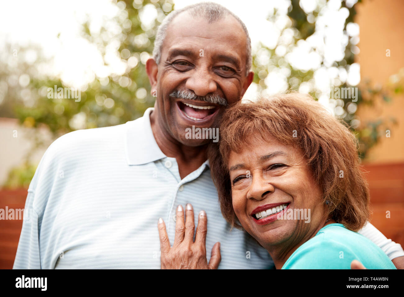 Senior di marito e moglie che abbraccia, sorridente alla telecamera, close up Foto Stock