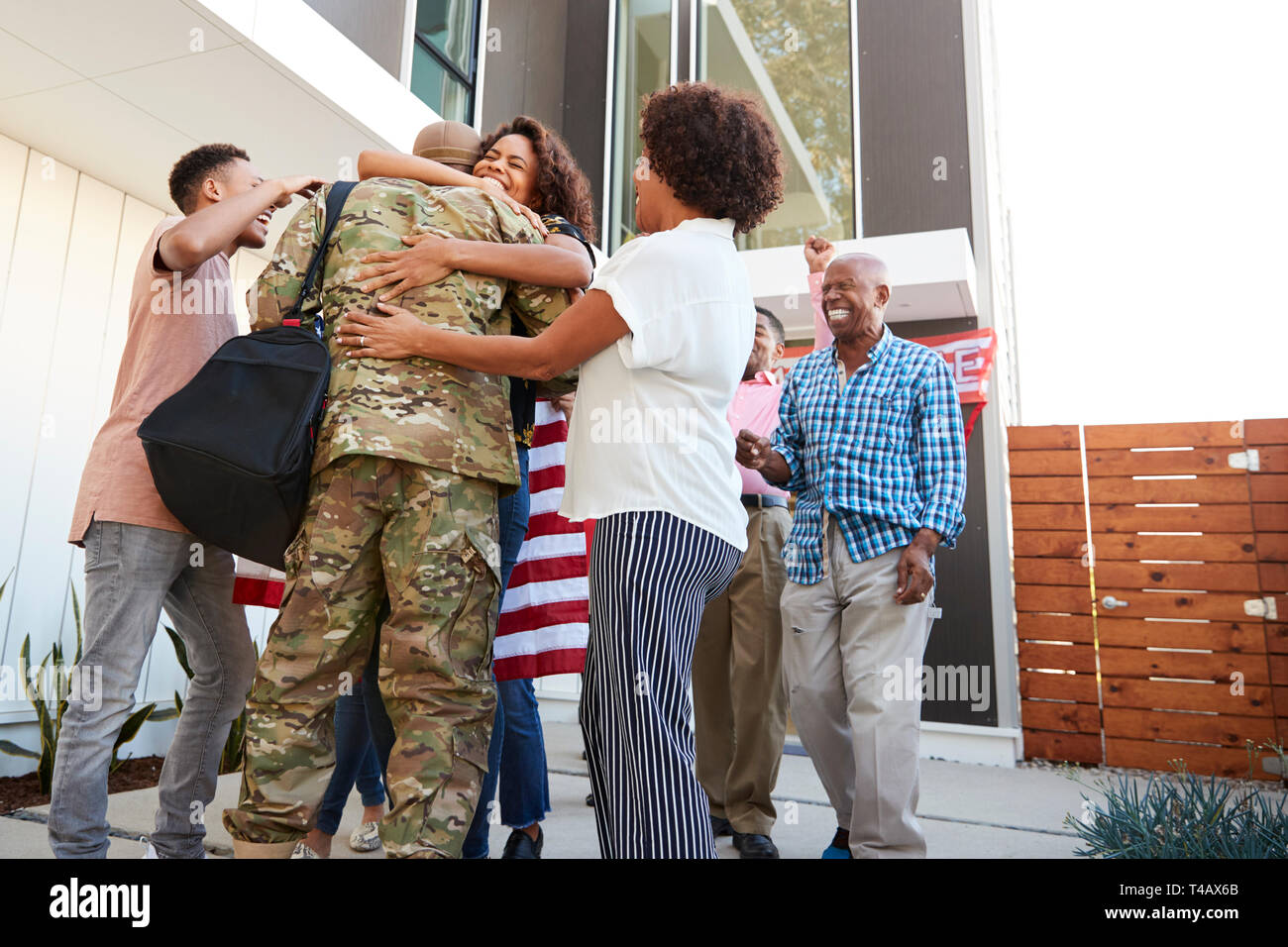 Tre generazioni della famiglia nero accogliente millenario soldato maschio tornando a casa,basso angolo di visione Foto Stock