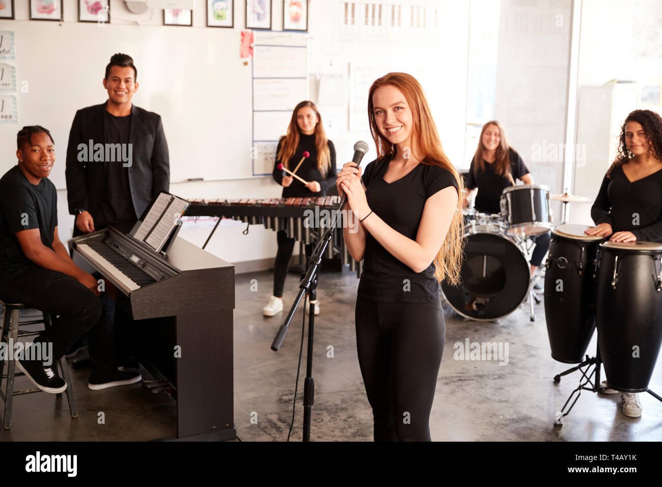 Ritratto di studenti della Performing Arts School giocando in banda a prova con l'insegnante Foto Stock