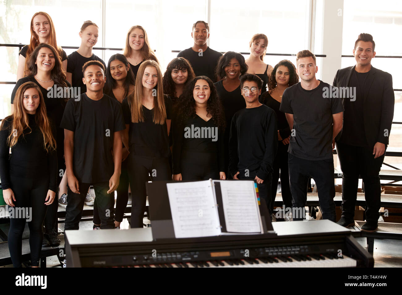 Ritratto di studenti maschi e femmine a cantare in coro con insegnante a Performing Arts School Foto Stock