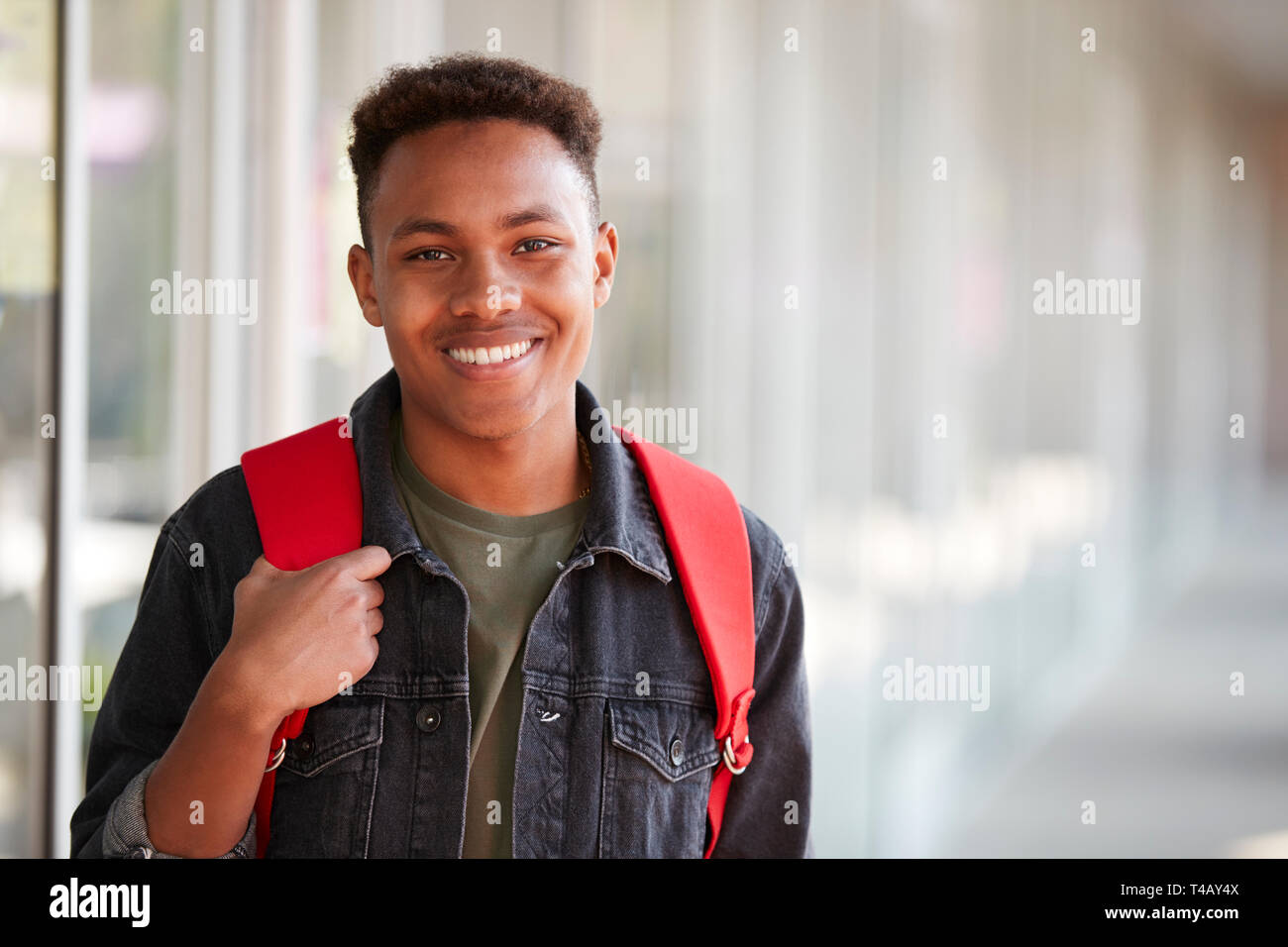 Ritratto di sorridere maschio Studente universitario con zaino in corridoio del Collegio di costruzione Foto Stock