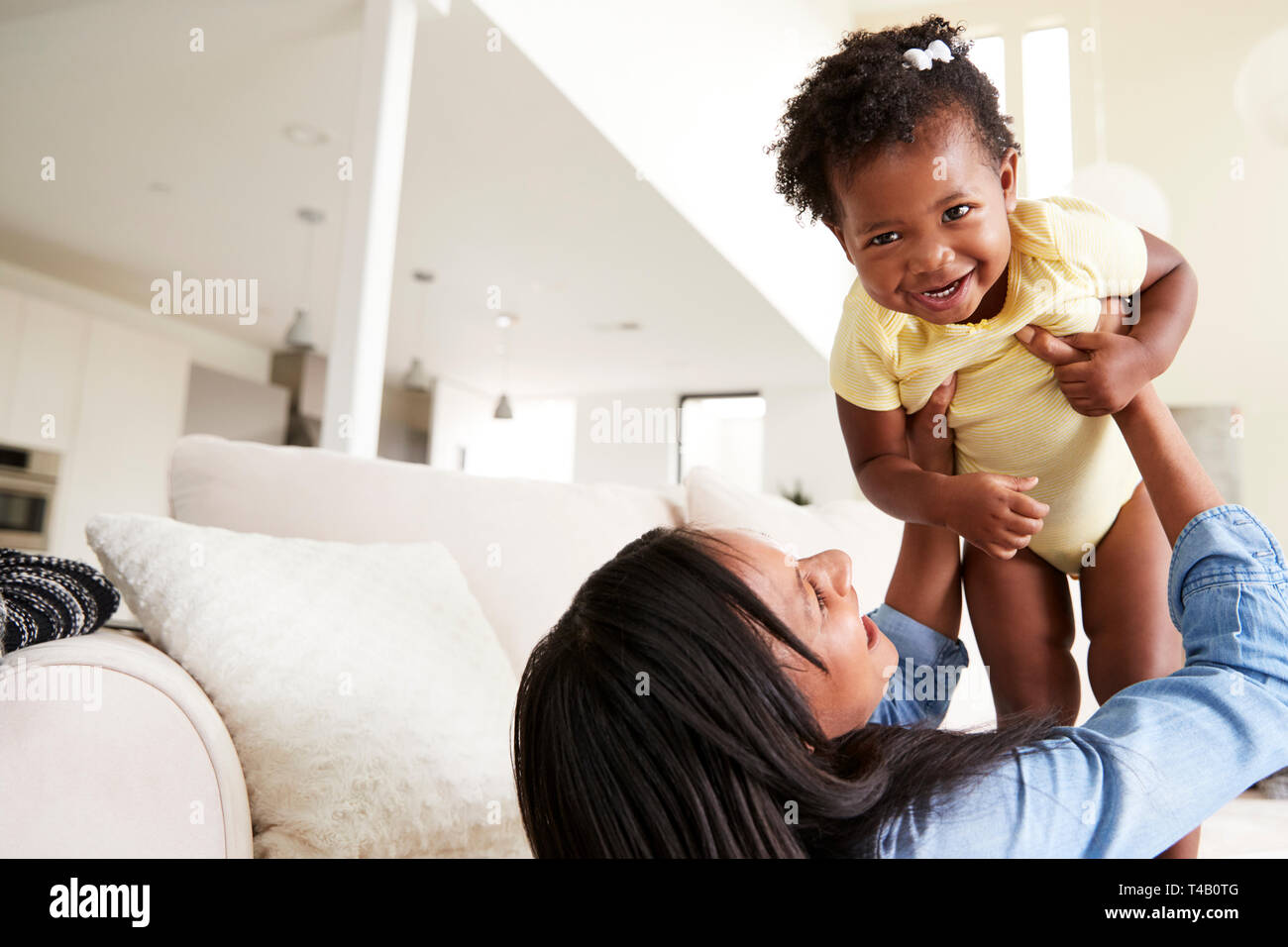 La madre gioca con la nostra bambina sollevando la sua nell'aria di casa Foto Stock