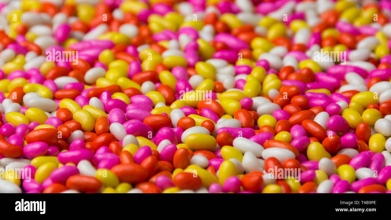 Coloratissima caramella dolce sfondo multi-color cioccolato isolato di pattern con sfondo nero colorato sfondo HD Foto Stock