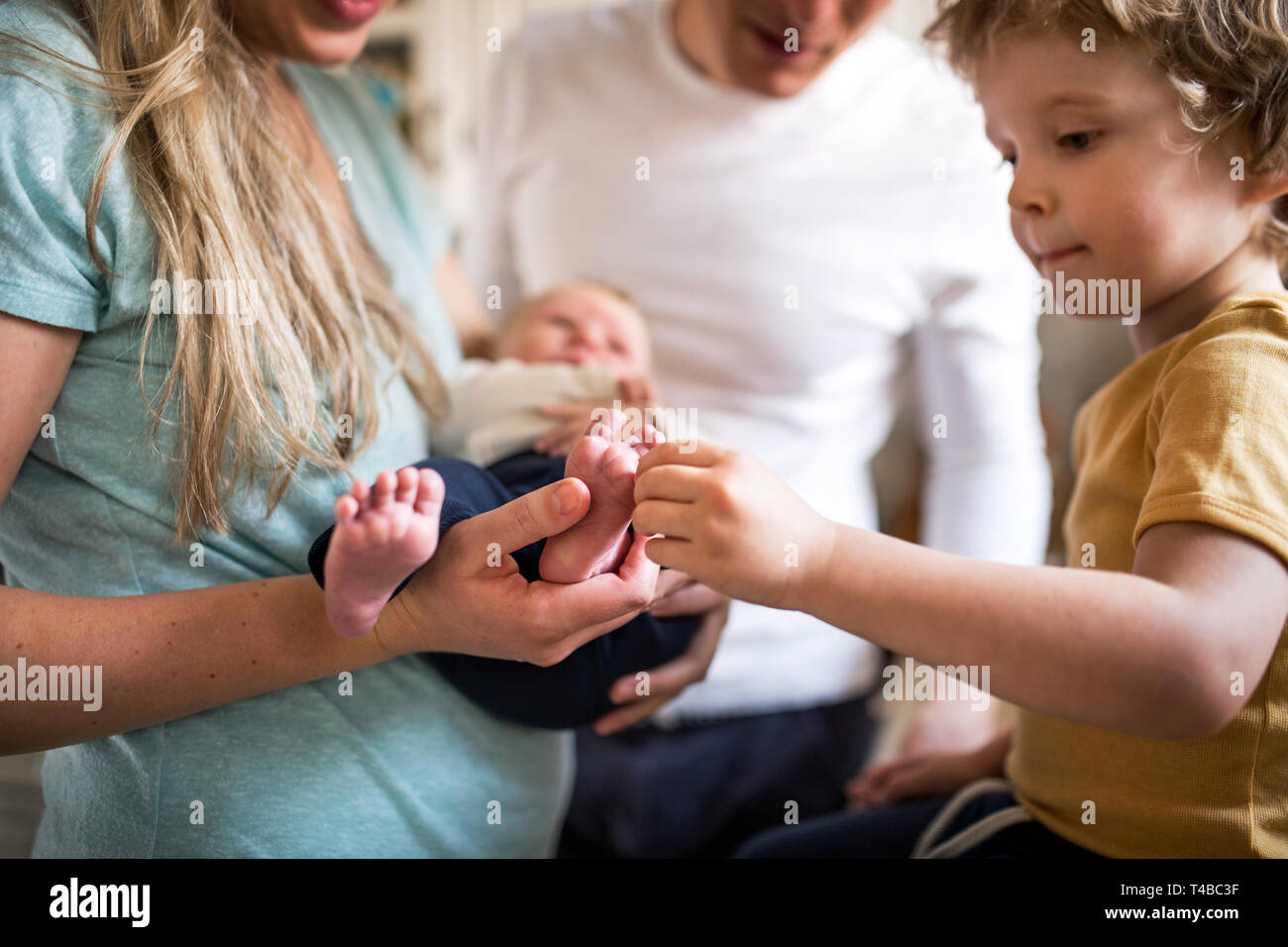 Sezione mediana dei genitori con un neonato e piccolo bimbo figlio a casa. Foto Stock