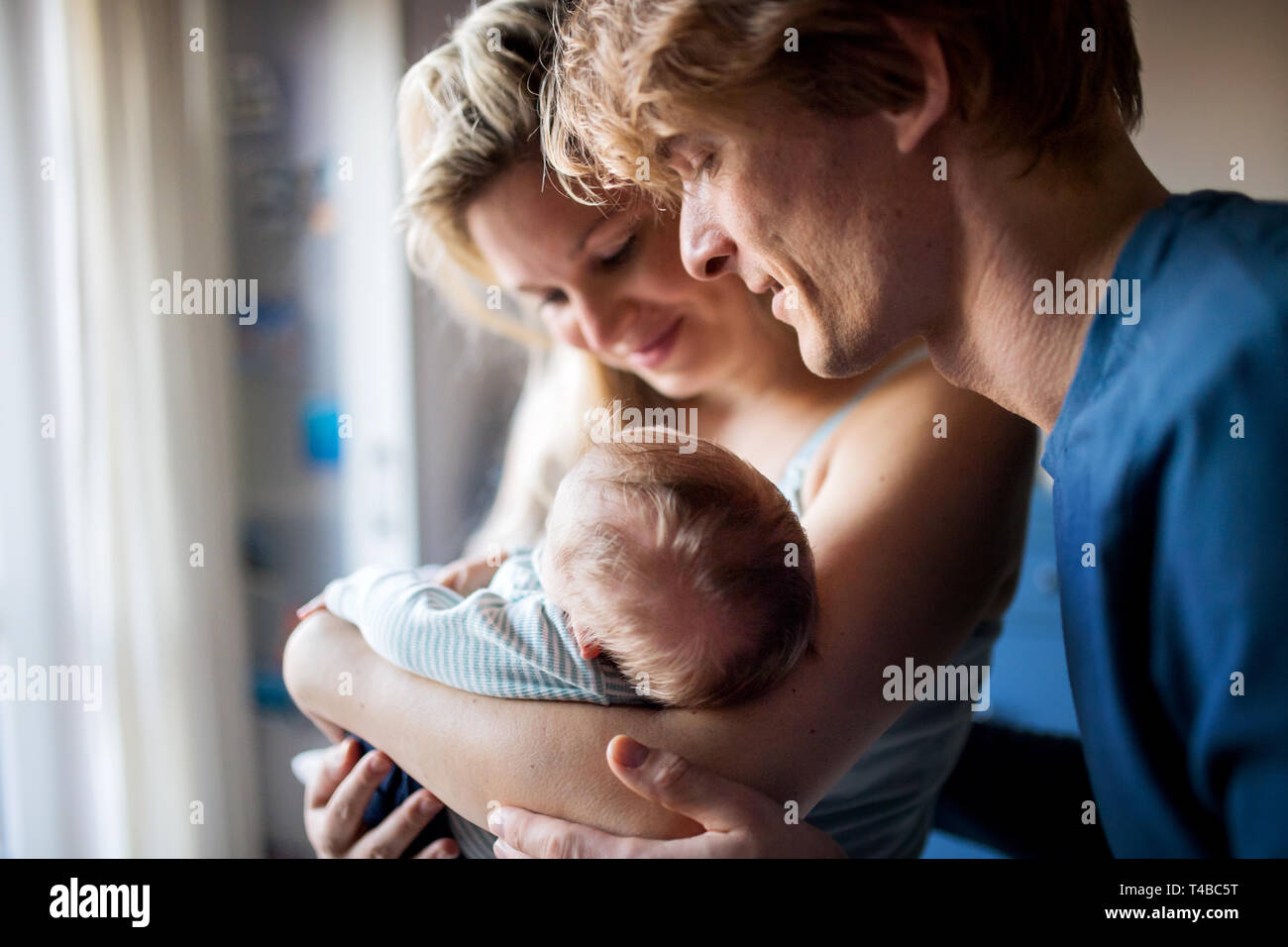 Bella giovani genitori con un neonato in casa. Foto Stock