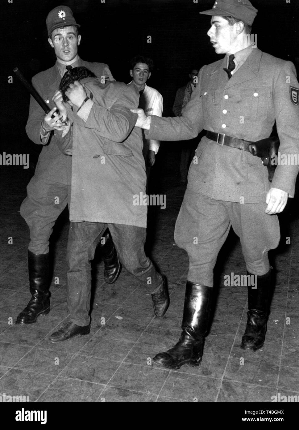 Gli uomini della polizia portano un giovane uomo off dopo la Bill Haley-concerto il 29 ottobre nel 1958 a Stoccarda. Vi erano state turmoils durante il concerto. | Utilizzo di tutto il mondo Foto Stock