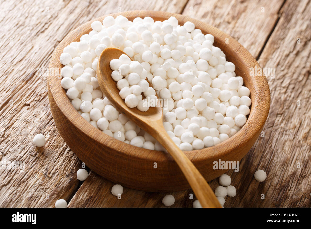 Perle di tapioca sono ad alto contenuto di carboidrati in una ciotola su una tavola di legno orizzontale. Foto Stock