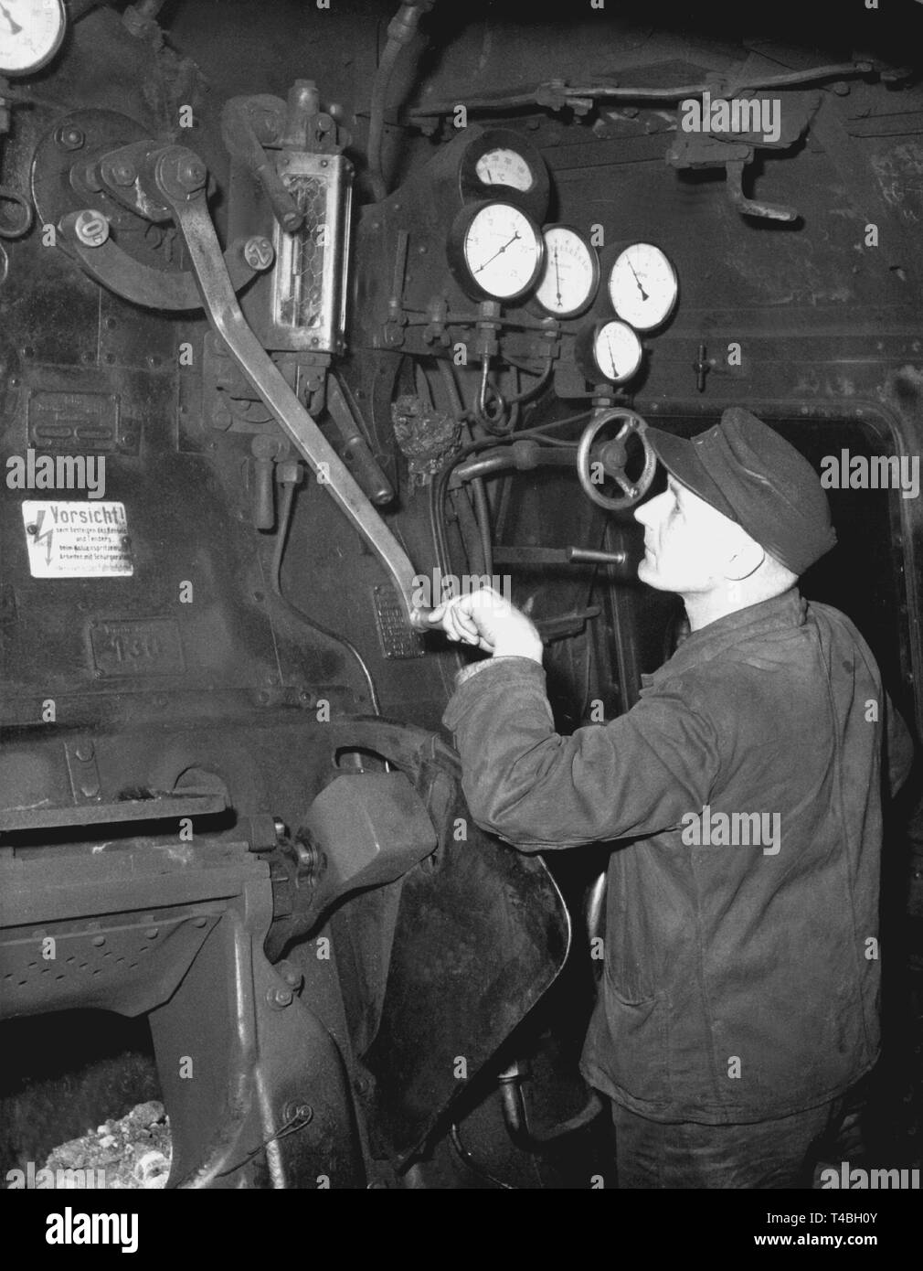 Driver del motore nella sua locomotiva a vapore nel 1954. | Utilizzo di tutto il mondo Foto Stock