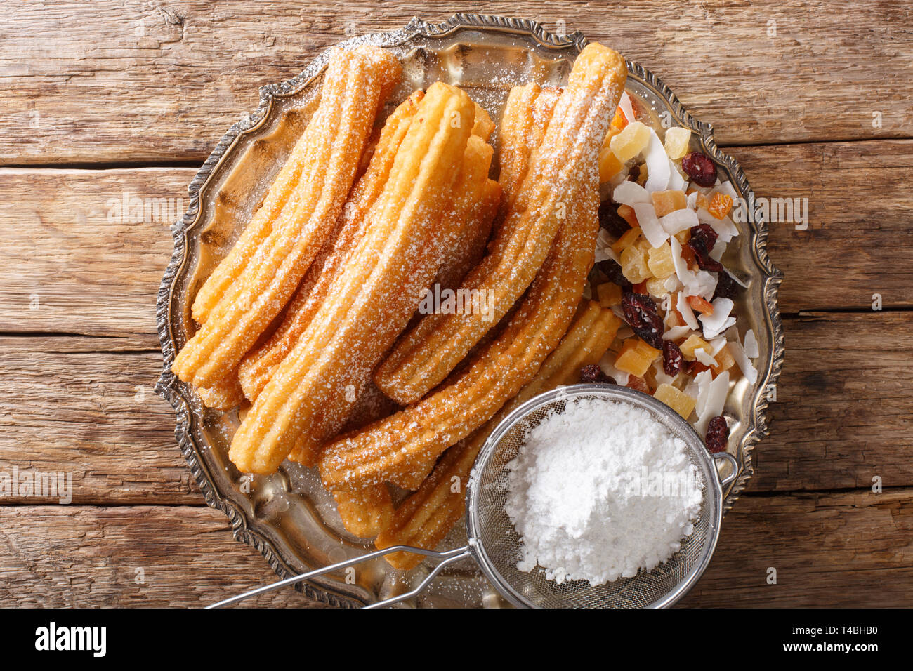Deliziosa casa churros con glassa di zucchero e frutta candita vicino sul tavolo. parte superiore orizzontale vista da sopra Foto Stock
