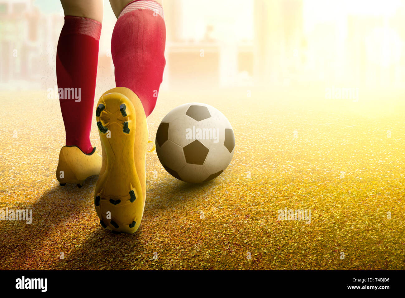 Vista posteriore del giocatore di football donna in maglia arancione calciare la palla sul campo di calcio Foto Stock
