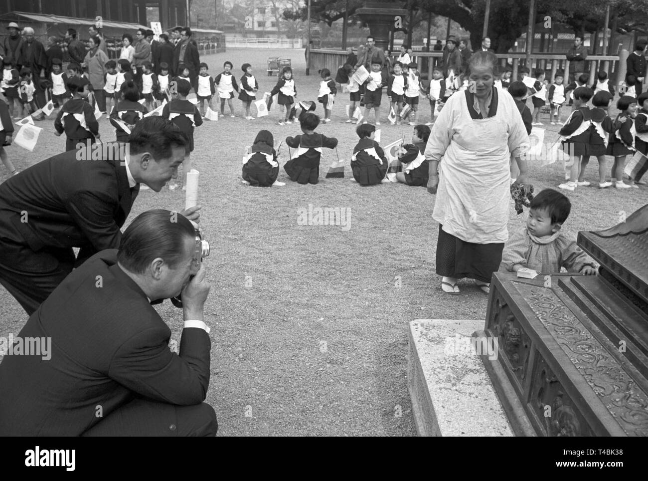 Il 16 novembre 1963, il ministro tedesco degli affari esteri Gerhard Schröder (anteriore) prende le fotografie di un piccolo ragazzo giapponese durante la visita di stato in Giappone dove aveva accompagnato Lübke. | Utilizzo di tutto il mondo Foto Stock