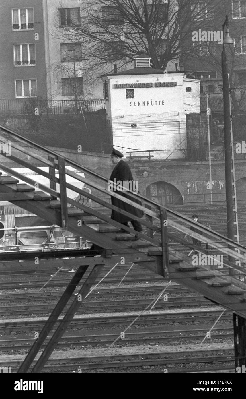 Un dipendente della ferrovia sta andando su per le scale fino alla 'Sennhütte' sopra il cantiere di classificazione a Dusseldorf il 18 dicembre 1963. | Utilizzo di tutto il mondo Foto Stock