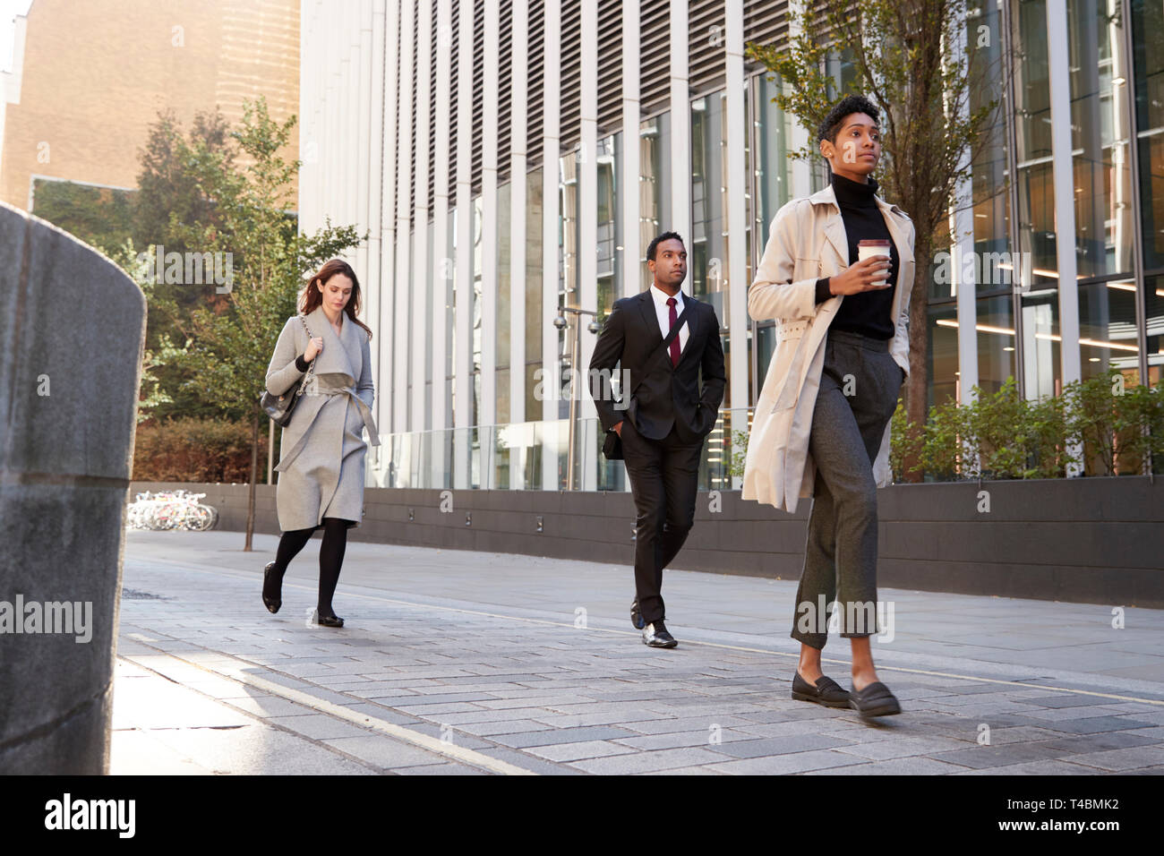 Tre città millenare lavoratori a piedi in strada, angolo basso a piena lunghezza Foto Stock