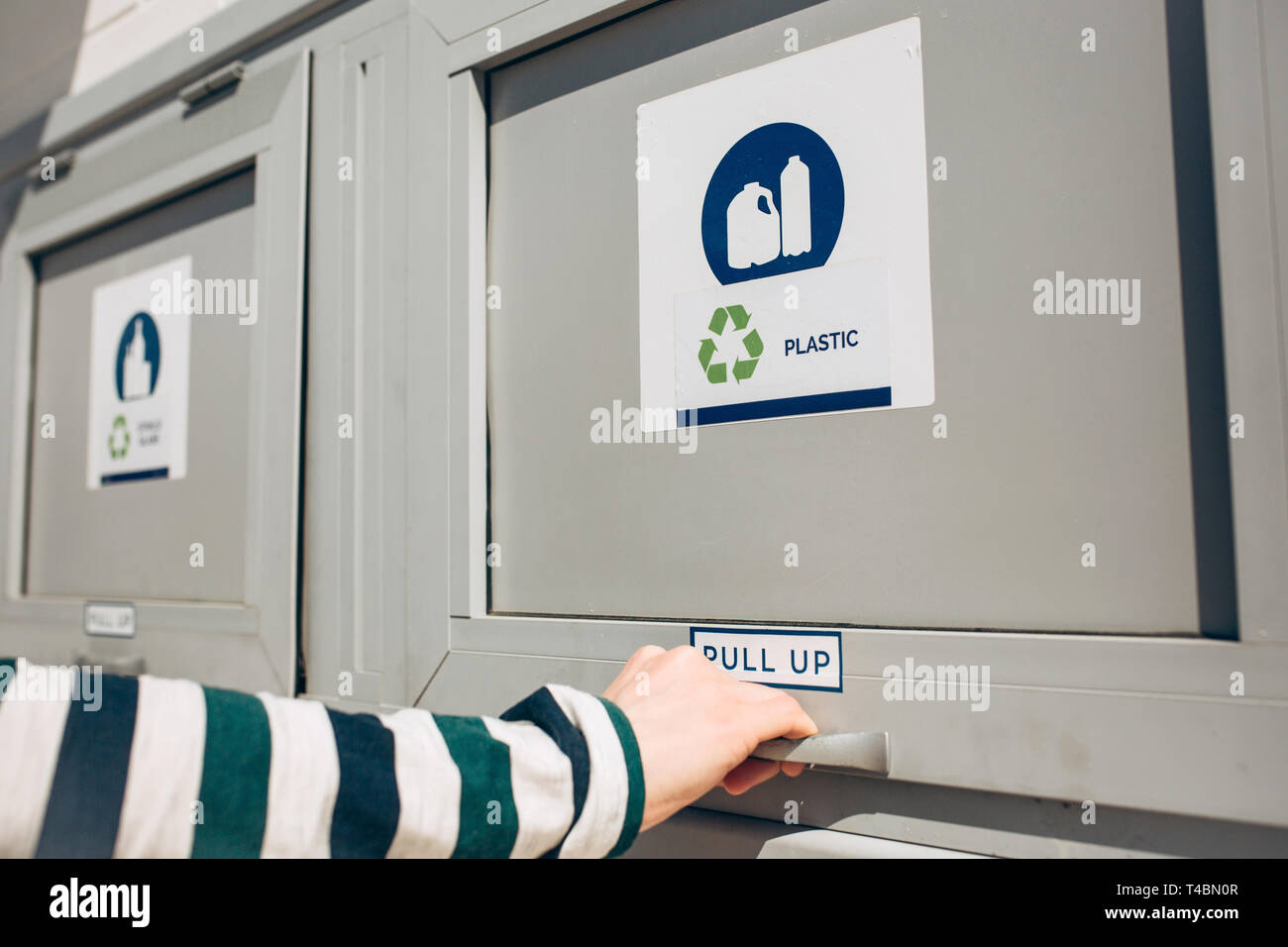 Una persona che si apre o si chiude un moderno bidone dei rifiuti per la raccolta differenziata dei rifiuti. Foto Stock