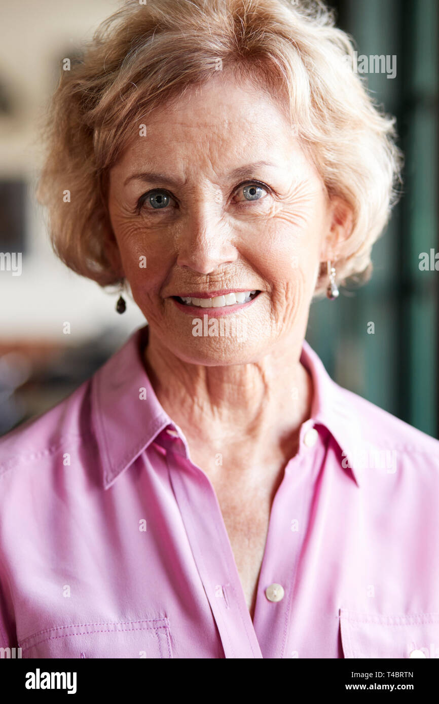 Ritratto di sorridere Senior donna seduta in Ristorante Foto Stock
