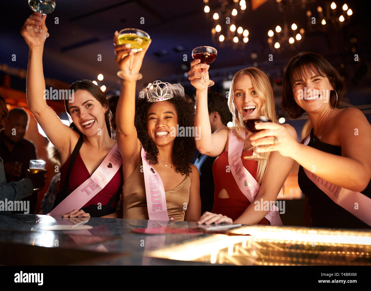 Il gruppo di amici di sesso femminile celebrando con sposa sulla parte di gallina in bar Foto Stock