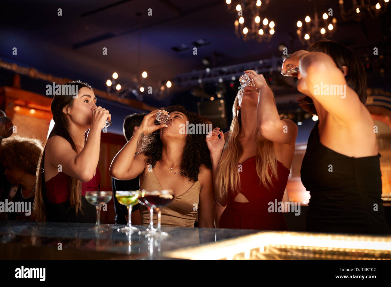 Il gruppo di amici di sesso femminile di bere colpi nel Cocktail Bar insieme Foto Stock