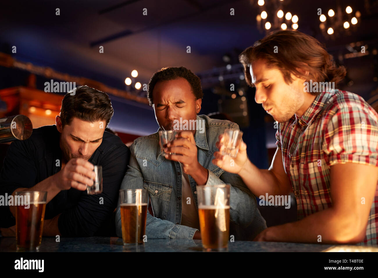 Gruppo di amici maschi di bere colpi nel Bar insieme Foto Stock