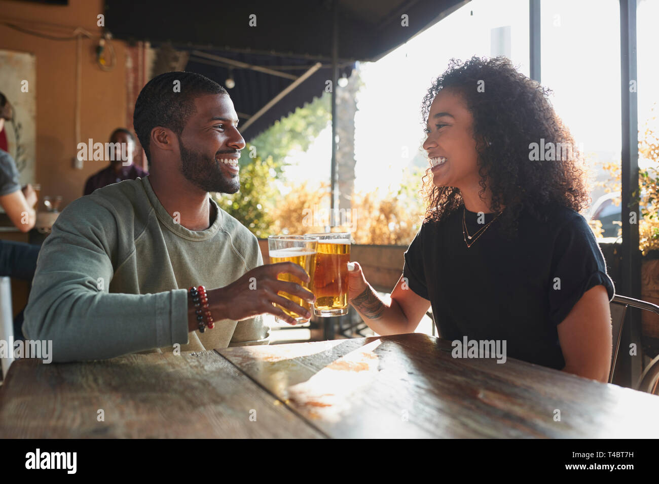 Coppia giovane incontro in Sports Bar godendo di bere prima del gioco Foto Stock