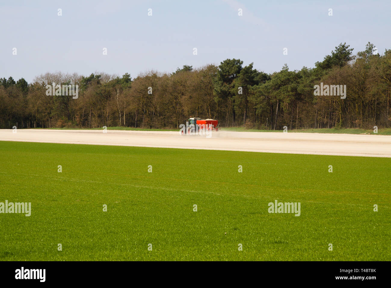 ROERMOND, Paesi Bassi - 30 marzo. 2019: Chalk Domanda di fertilizzante per trattore con spanditore per preparare il campo per la coltivazione di prato Foto Stock