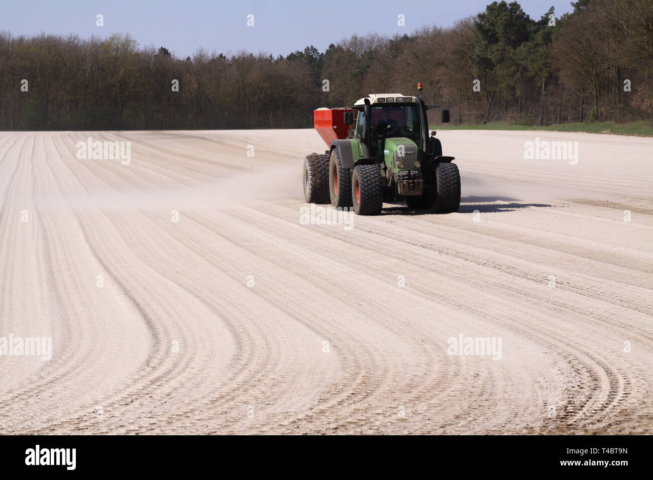 ROERMOND, Paesi Bassi - 30 marzo. 2019: Chalk Domanda di fertilizzante per trattore con spanditore per preparare il campo per la coltivazione di prato Foto Stock