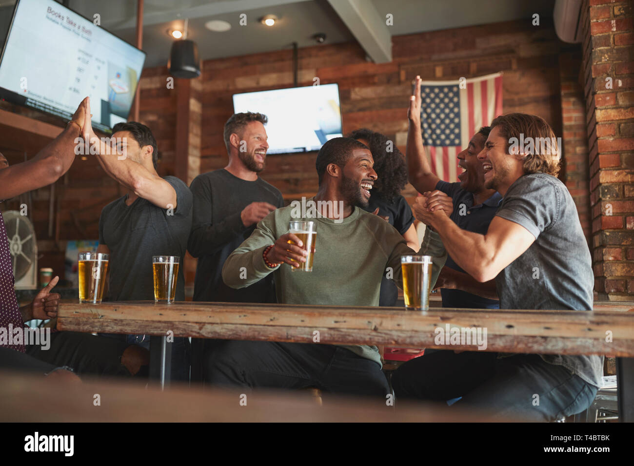 Gruppo di amici la visione di gioco sullo schermo in Sports Bar Foto Stock