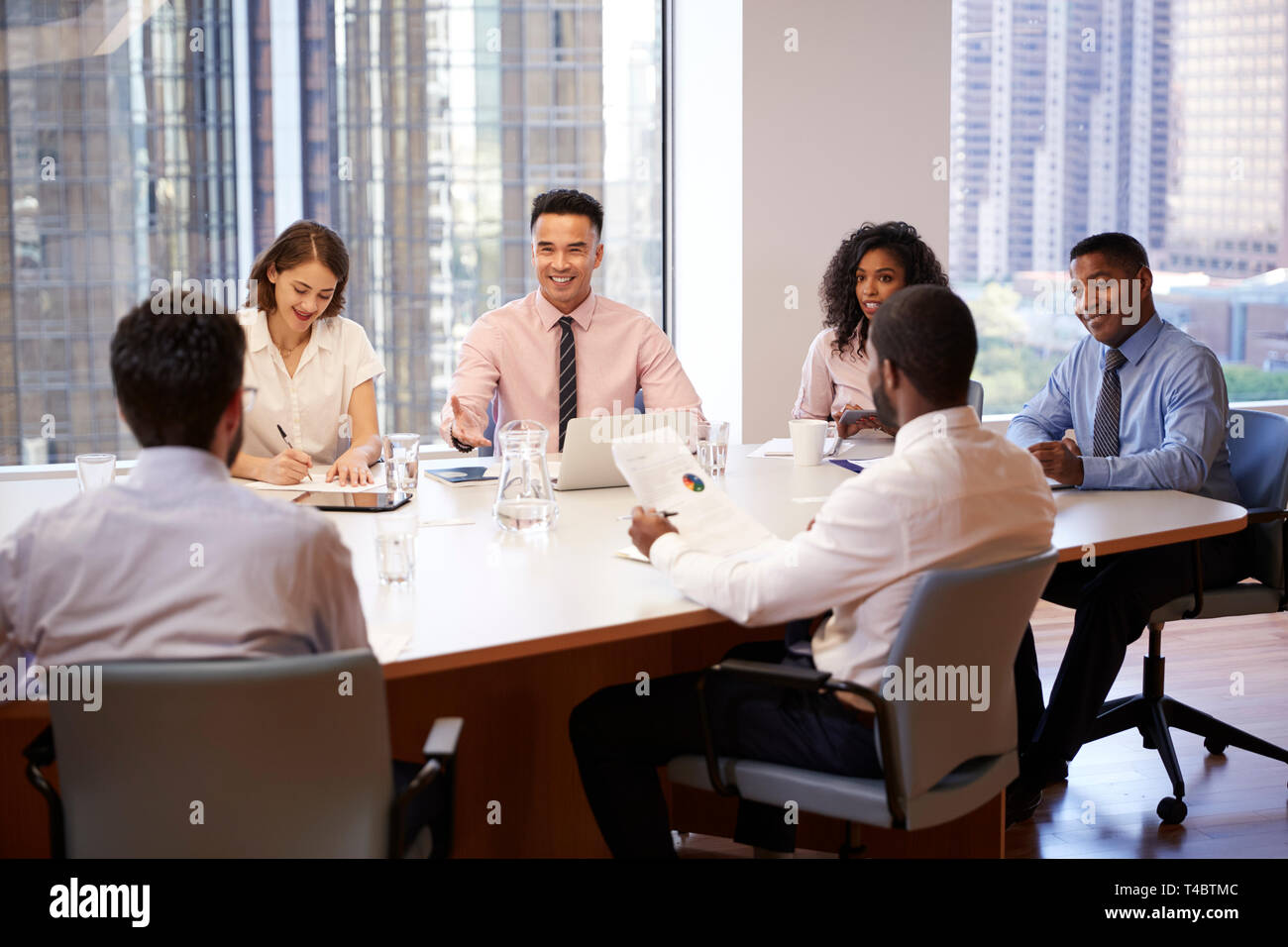 Gruppo di professionisti riuniti intorno al tavolo in ufficio moderno Foto Stock