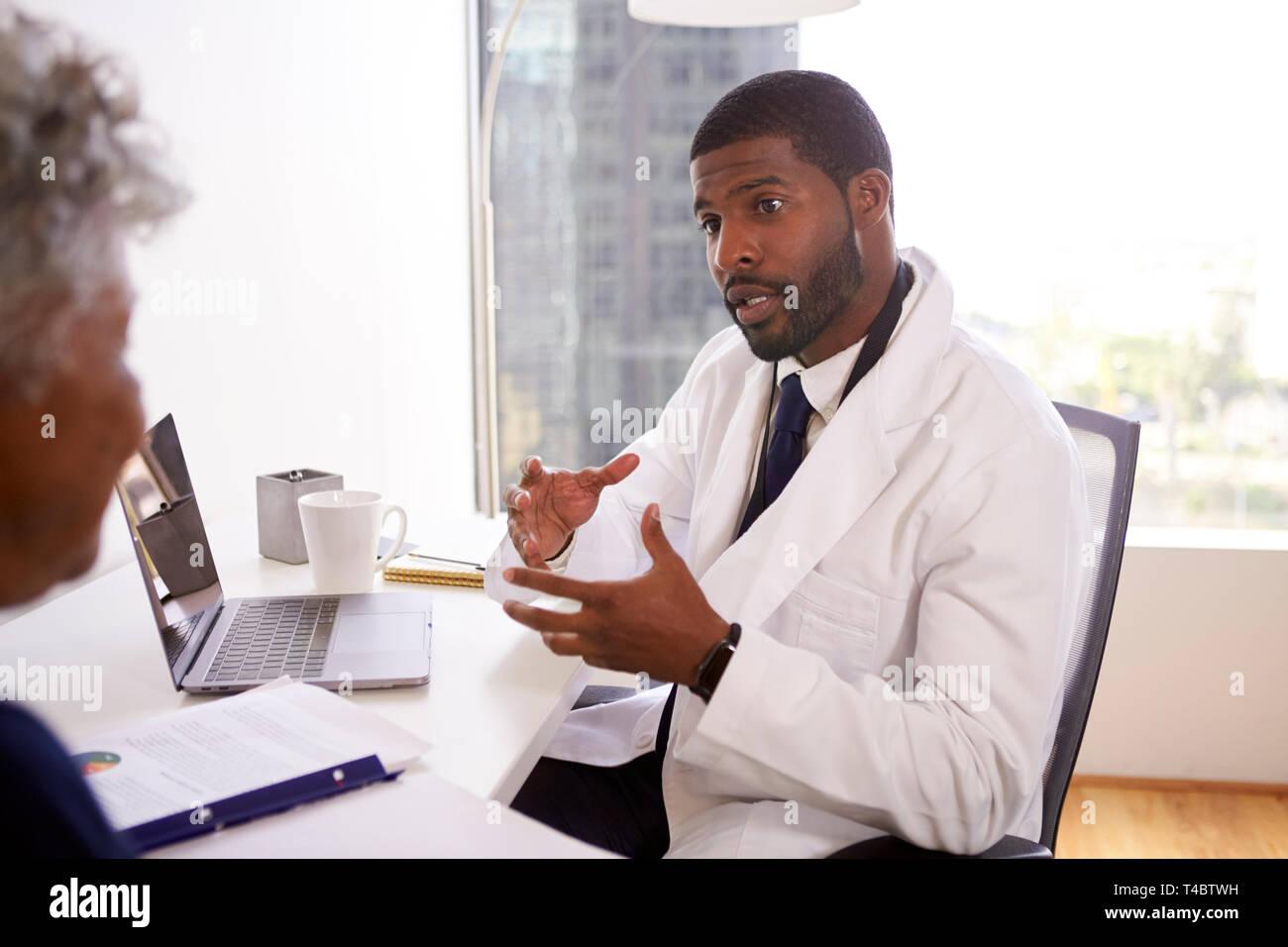 Senior donna incontro con connettore maschio di tipo medico chirurgo cosmetico in Office Foto Stock