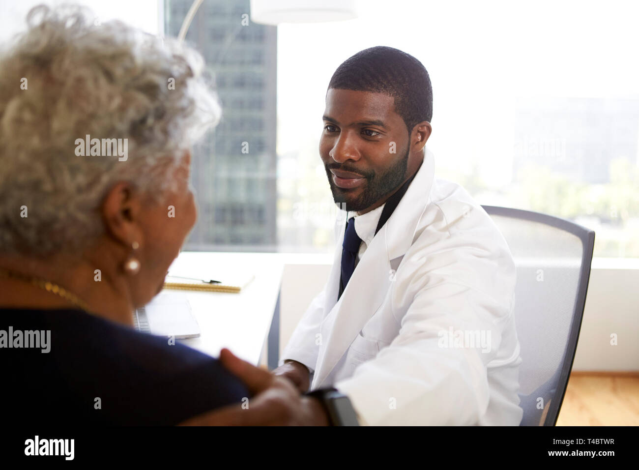 Senior donna incontro con connettore maschio di tipo medico chirurgo cosmetico in Office Foto Stock