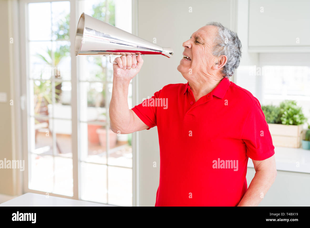 Senior shouthing uomo eccitato attraverso il metallo vintage megafono Foto Stock