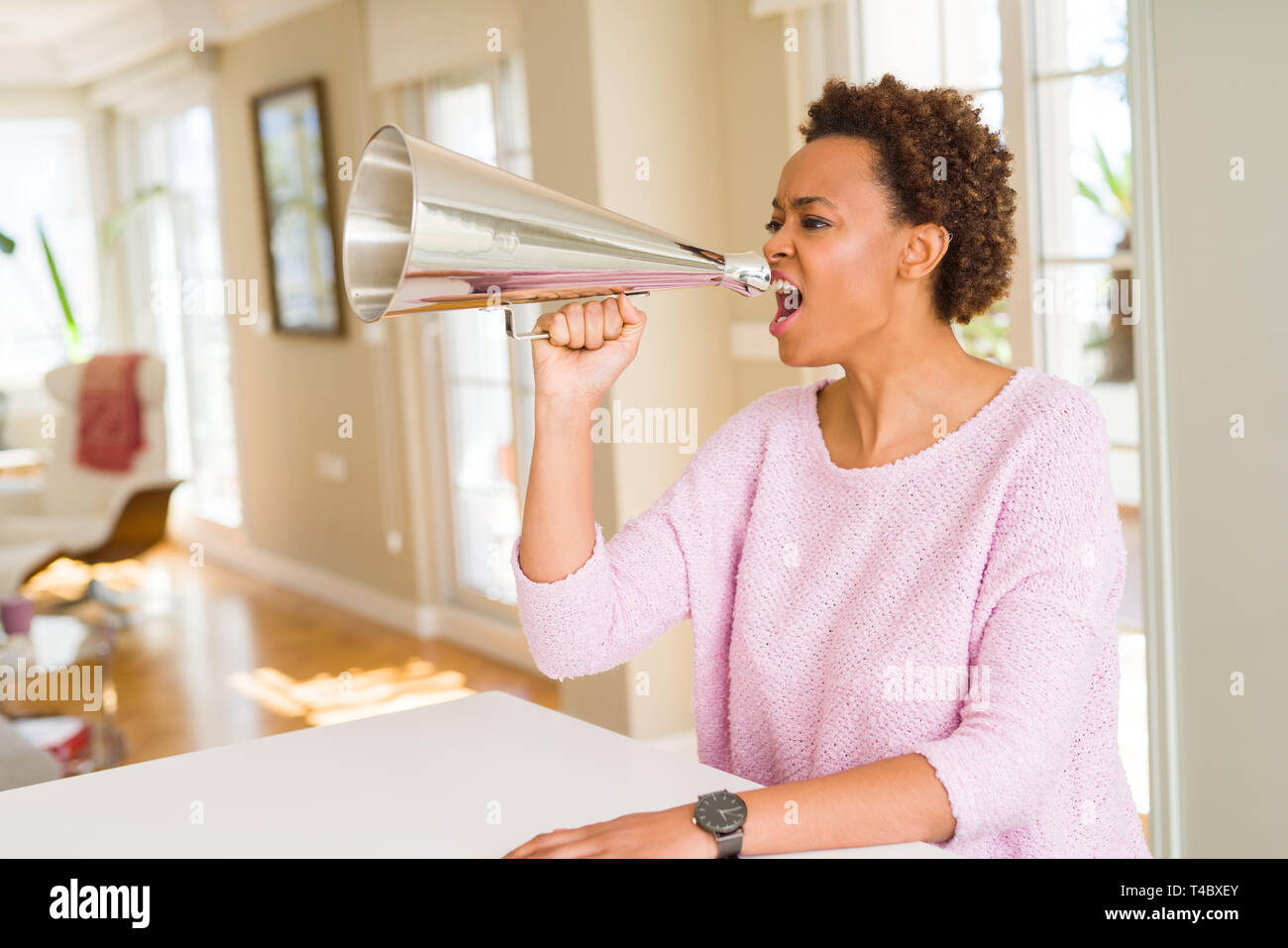 Giovani belle americano africano donna con capelli afro urlando utilizzando megafono Foto Stock