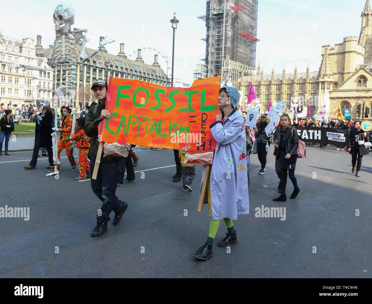 I manifestanti visto tenendo un banner durante la ribellione di estinzione mock il corteo funebre di dimostrazione. Estinzione della ribellione mock corteo funebre guidato da una banda di ottoni e grandi marionette scheletro di estinzione e le creature minacciate in piazza del Parlamento. Foto Stock