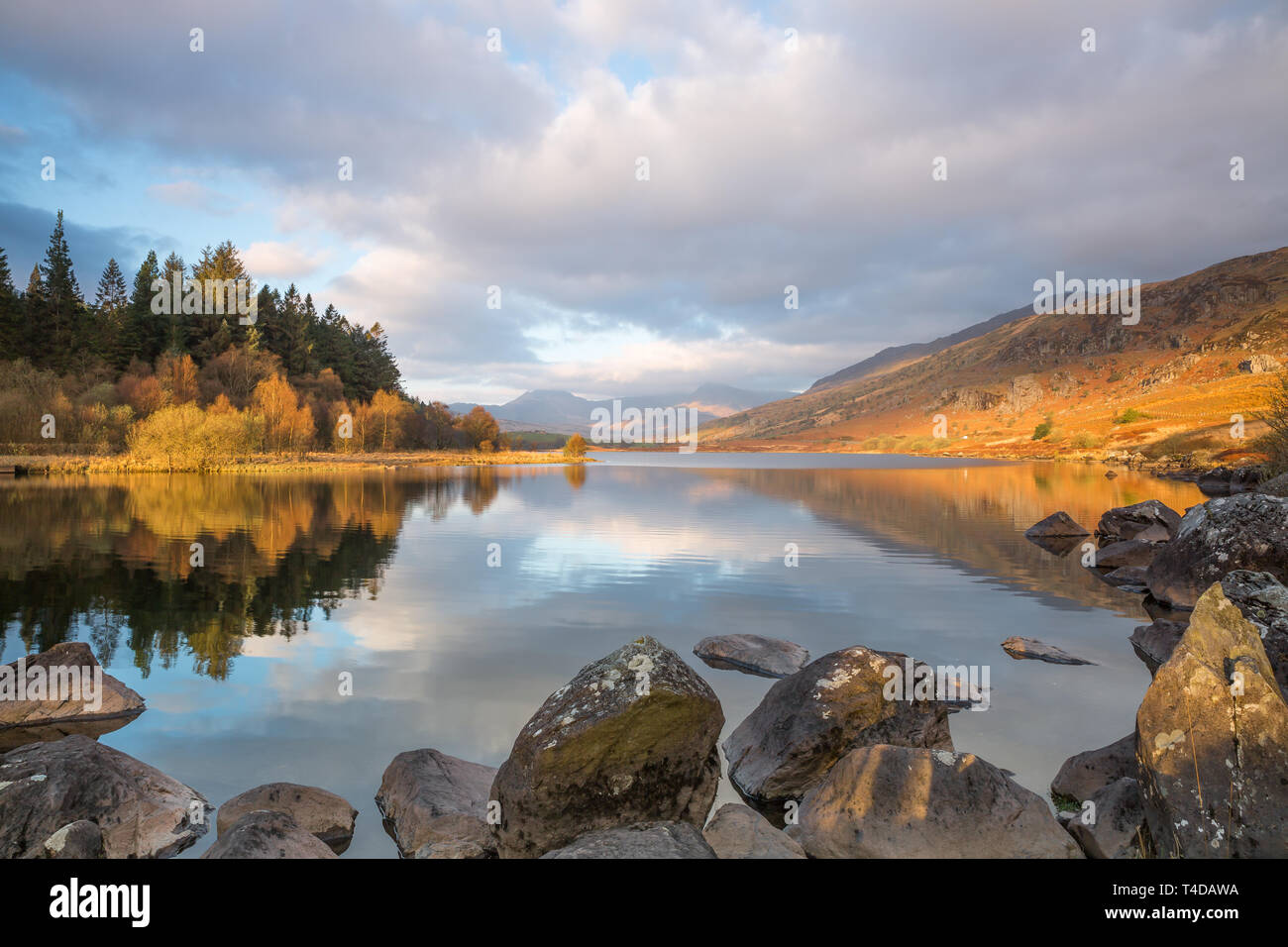 Moody, vista panoramica delle montagne di Snowdon Horseshoe all'alba, nelle nuvole riflesse nelle acque fisse di Llynnau Mymbyr, Snowdonia National Park, Galles UK. Foto Stock
