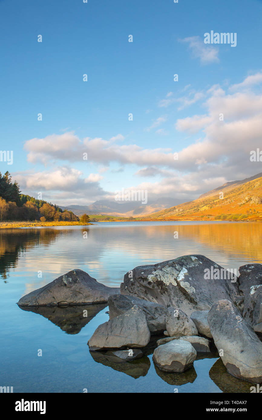 Scenic vista la mattina di Snowdon Horseshoe montagne nelle nuvole, riflessa nell'acqua ancora di Llynnau Mymbyr, Snowdonia National Park, il Galles del Nord, Regno Unito. Foto Stock