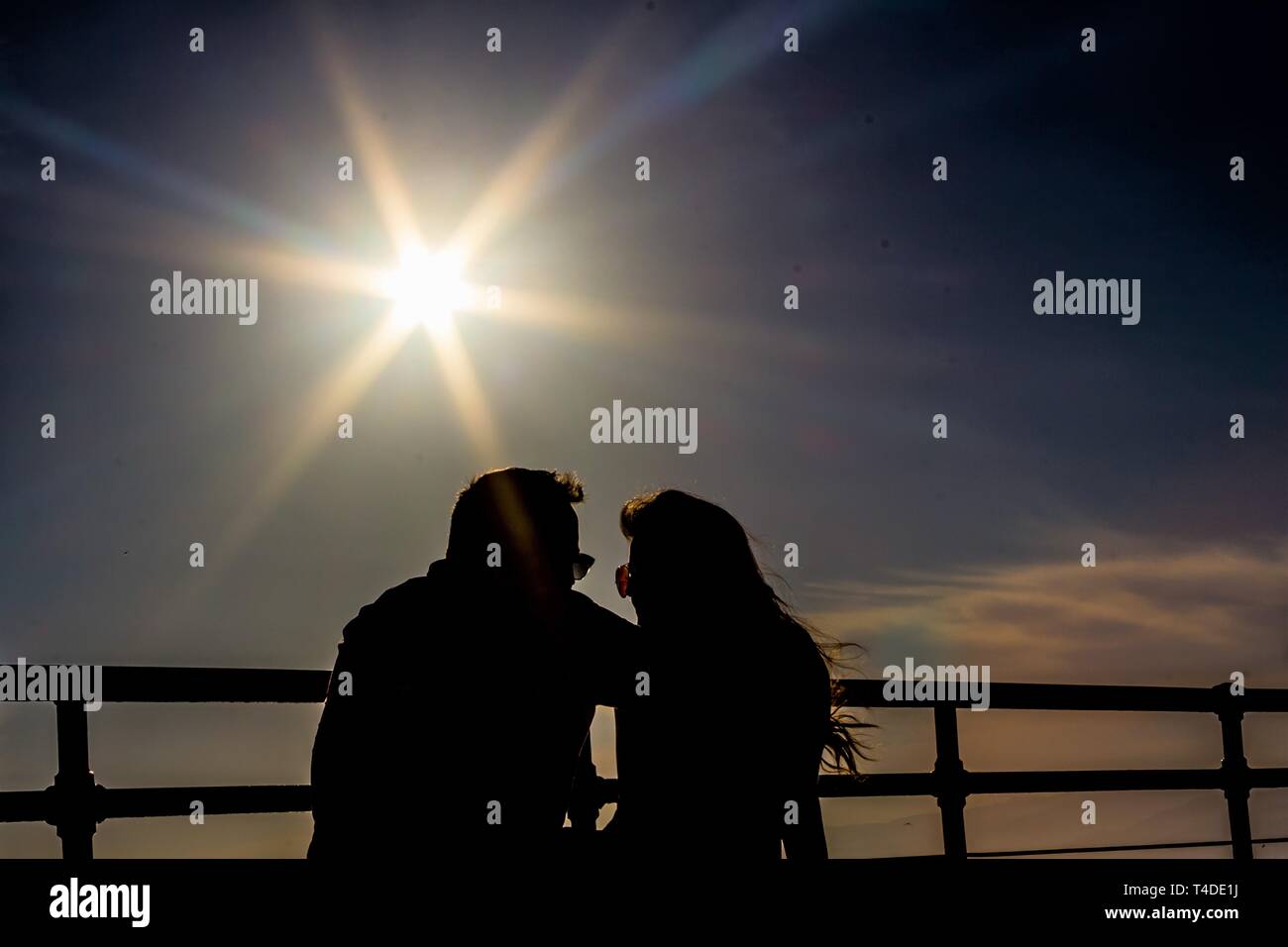 Giovane guardando a ogni altro starburst sotto al tramonto Foto Stock