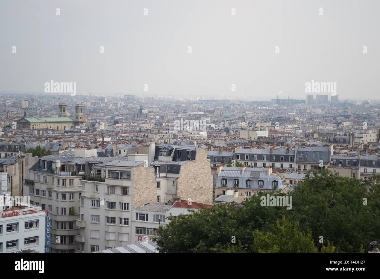 Nebuloso skyline di Parigi da Montmartre, Francia. N. di famosi punti di riferimento, semplicemente occupato affollata di basso livello, di alloggiamento con alti edifici moderni in distanza nebbia Foto Stock