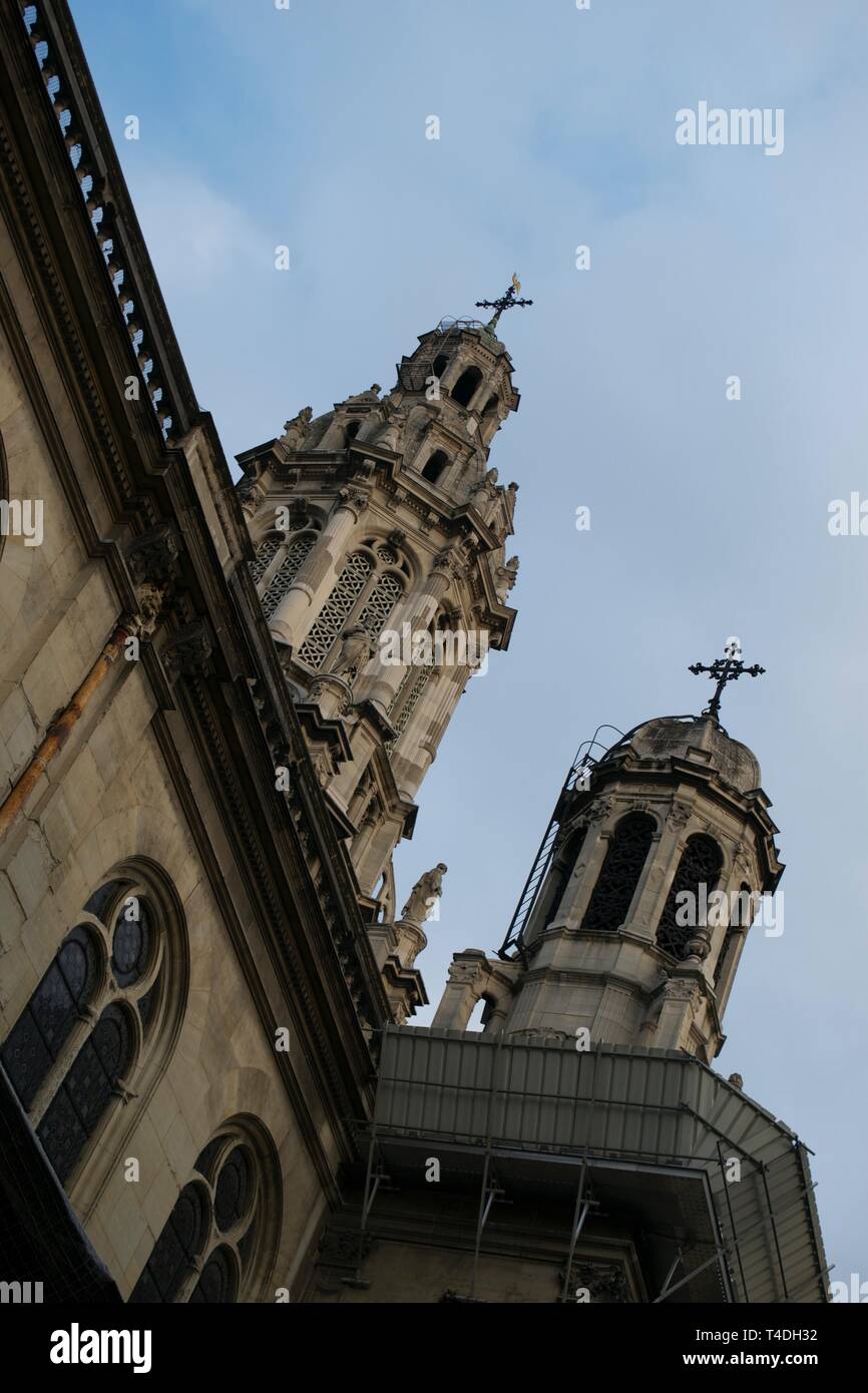 Guardando le torri di pietra e crocifissi sulla storica Chiesa di Parigi in Francia contro nuvoloso cielo blu Foto Stock