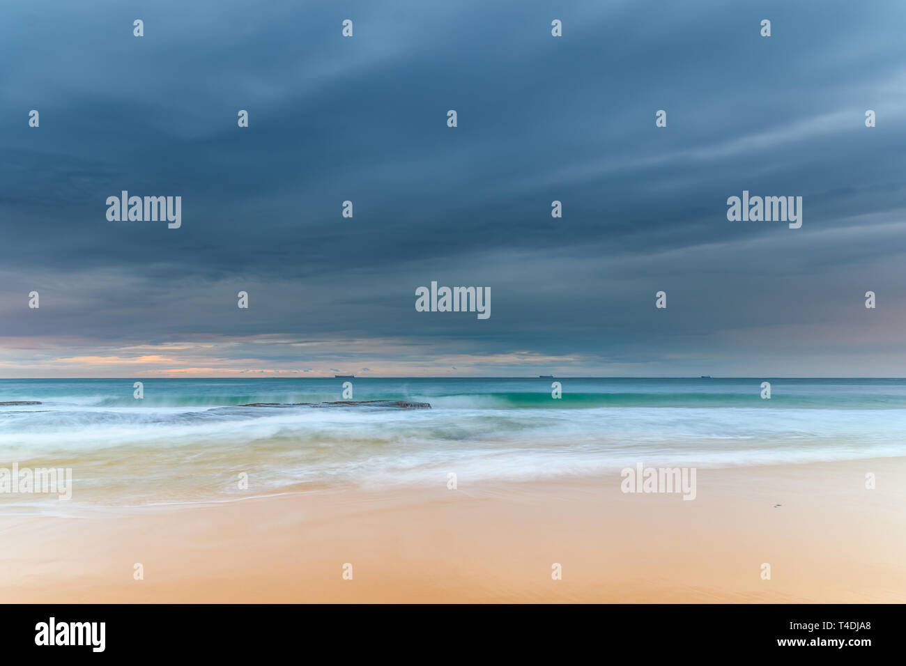 Catturare il sunrise dall'estremità nord della Forresters Beach sulla costa centrale, NSW, Australia. Foto Stock