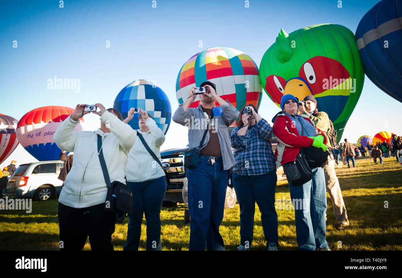 A curiosi di Albuquerque International Hot Air Balloon Festival di scattare foto come i palloncini prendono il volo. Foto Stock