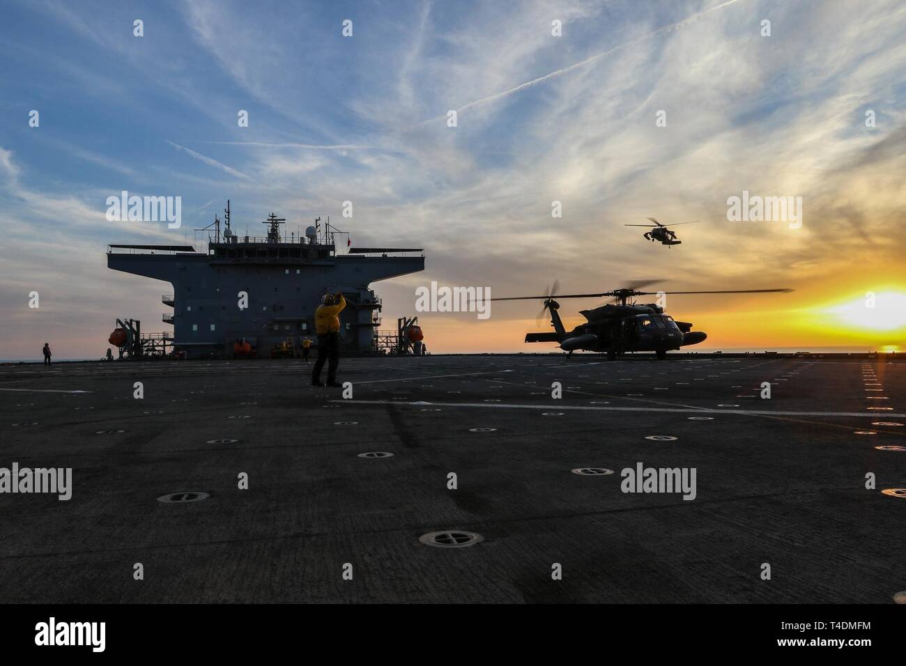 Stati Uniti I soldati dell esercito, assegnato all'1-108th elicottero d'assalto battaglione, Kansas Esercito Nazionale Guardia, condotta giorno e notte deck qualifiche di atterraggio con U.S. Esercito UH-60 Black Hawk elicotteri a bordo di un U.S. Nave della marina americana nel Golfo Arabico, Marzo 29, 2019. L'1-108th AHB dispiegato per il Medio Oriente per completare le missioni di aviazione a supporto delle operazioni di protezione Spartan e inerenti a risolvere. Foto Stock