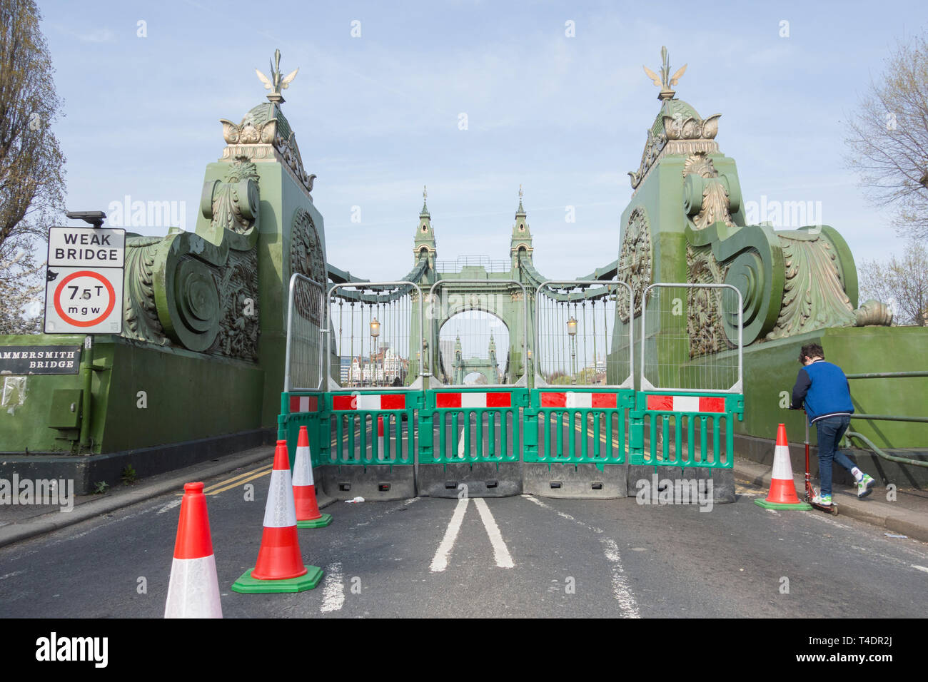 Un ragazzo su uno scooter attraversa Hammersmith Bridge, che è stato chiuso indefinitamente a automobili e autobus, ma è ancora aperto per pedoni e ciclisti Foto Stock