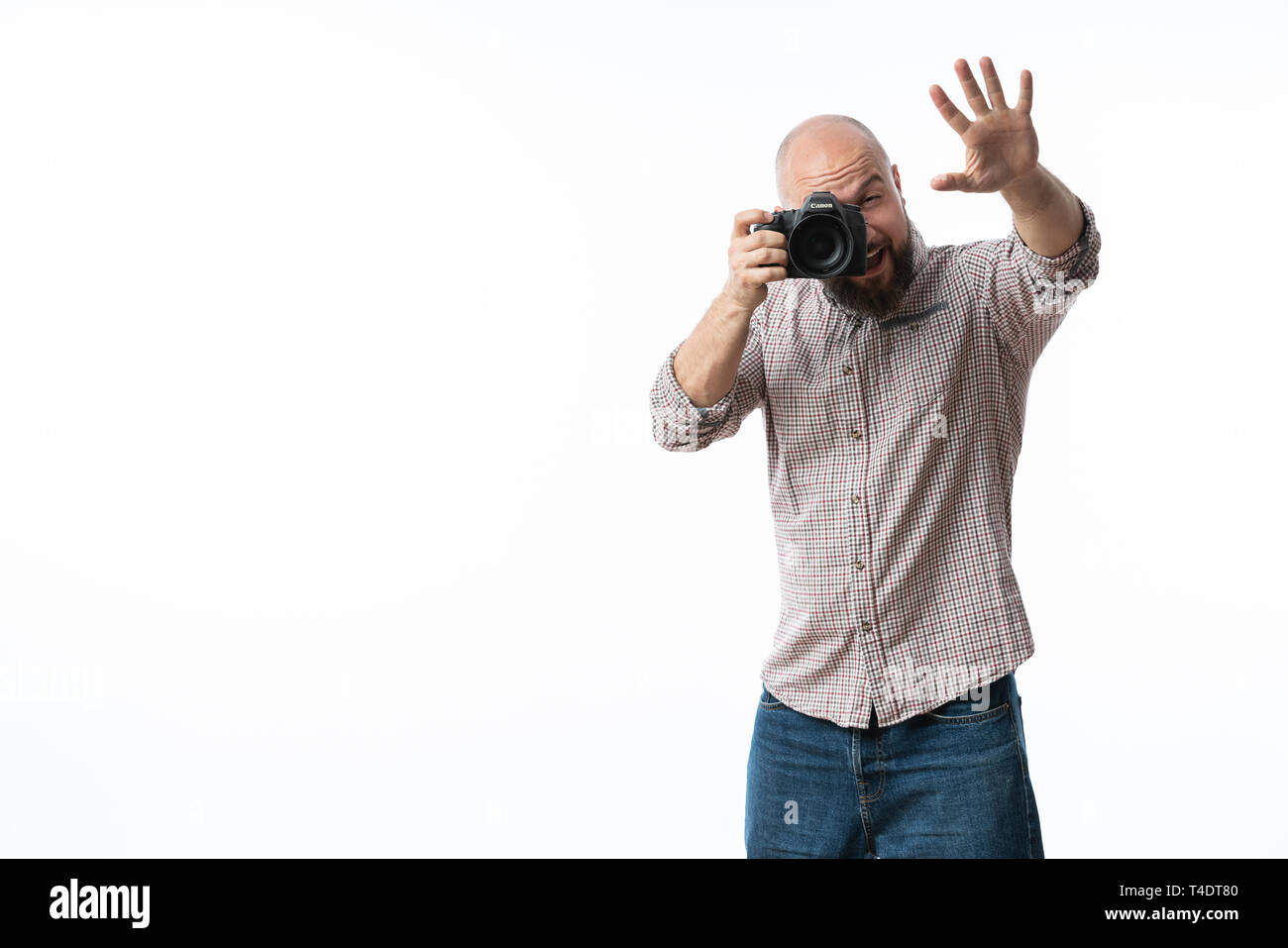 Giovane fotografo allegro con la barba, mentre lavora in studio Foto Stock