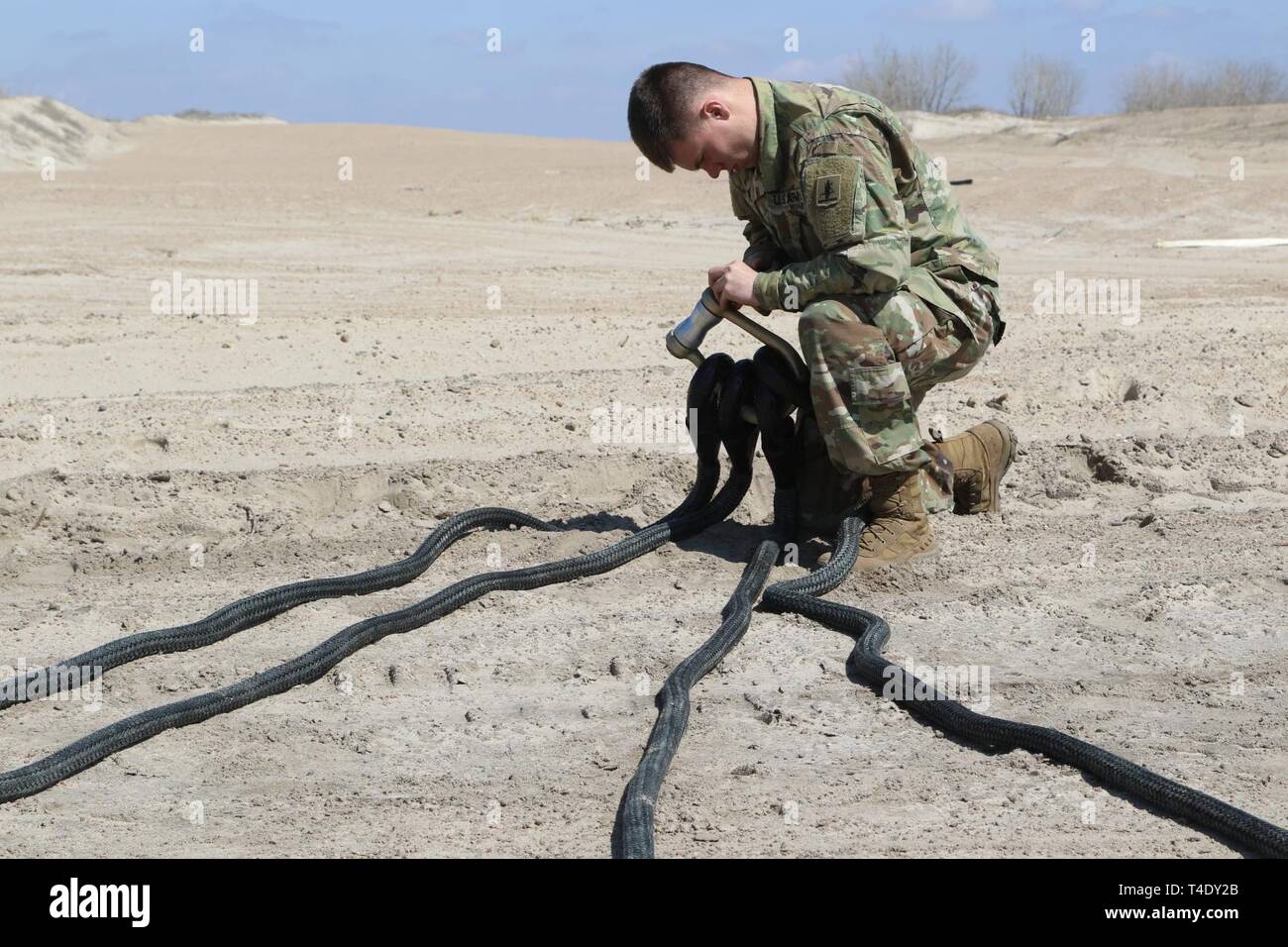 Il Nebraska Esercito Nazionale soldato di guardia, SPC. Giacobbe Mason, 195th, Intendente di distacco, Rigger Team di supporto (RST), prepara le imbracature e ancore prima di imbracatura operazioni di carico vicino a Genova, Nebraska, Marzo 26. Mason e altri riggers erano parte di un team che ha preparato un Bobcat caricatore per il trasporto di aria durante il diluvio gli sforzi di recupero al fiume Loup diga di diversione. (Nebraska Guardia Nazionale Foto Stock