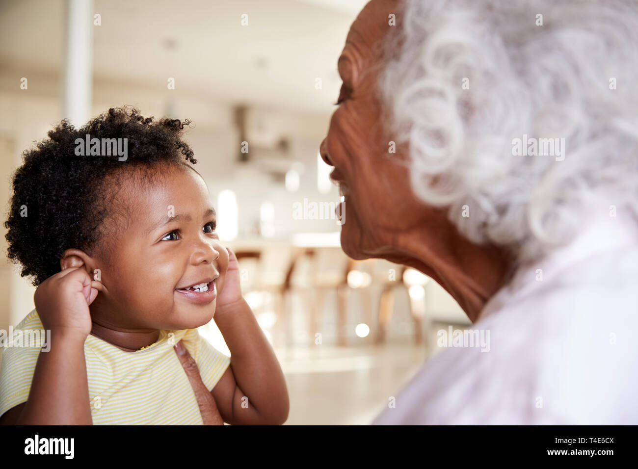 Nonna seduti sul divano di casa con il bambino nipote giocando insieme Foto Stock