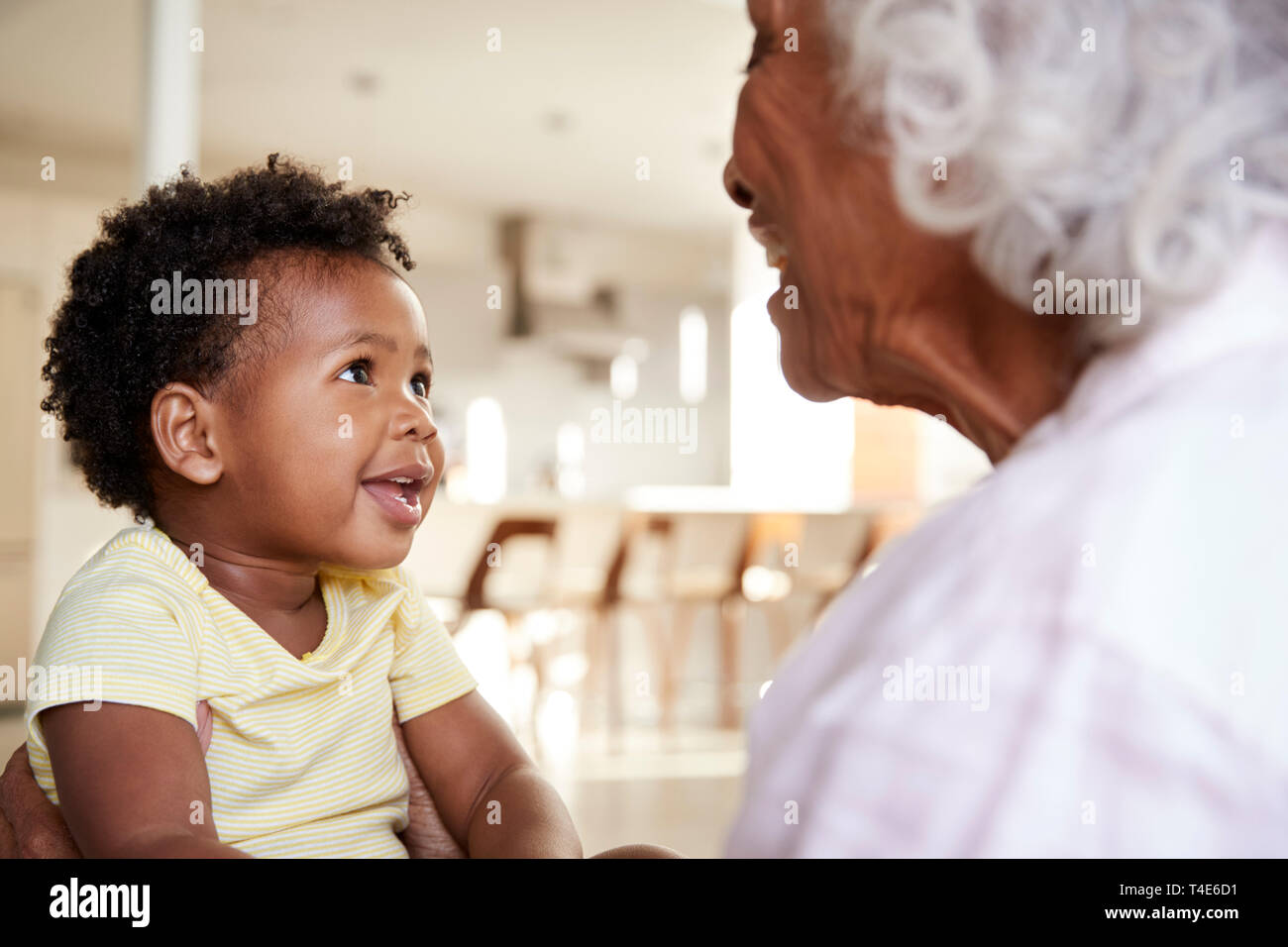 Nonna seduti sul divano di casa con il bambino nipote giocando insieme Foto Stock