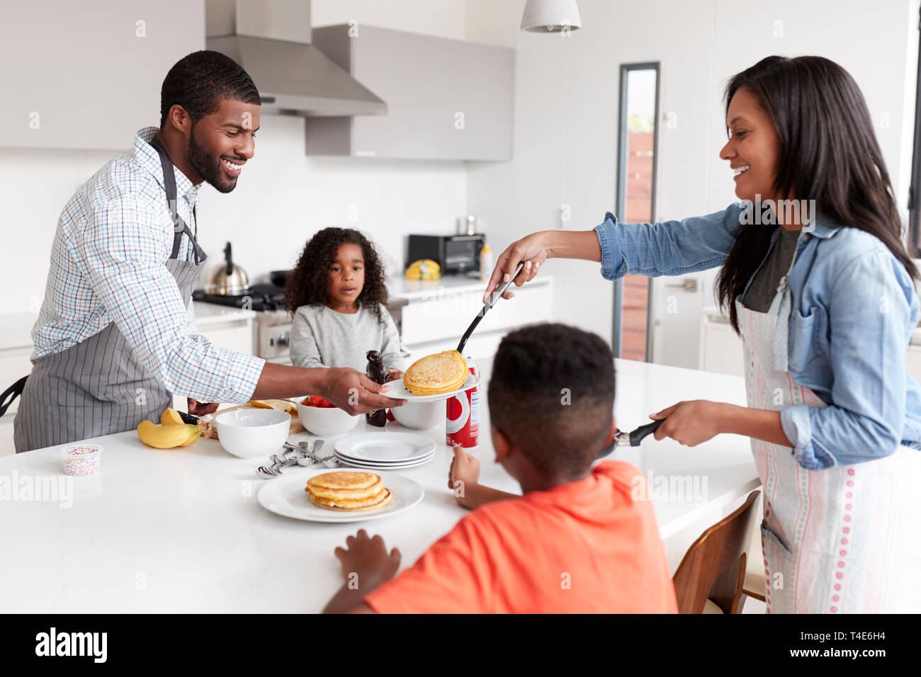 Famiglia nella cucina di casa rendendo frittelle insieme Foto Stock