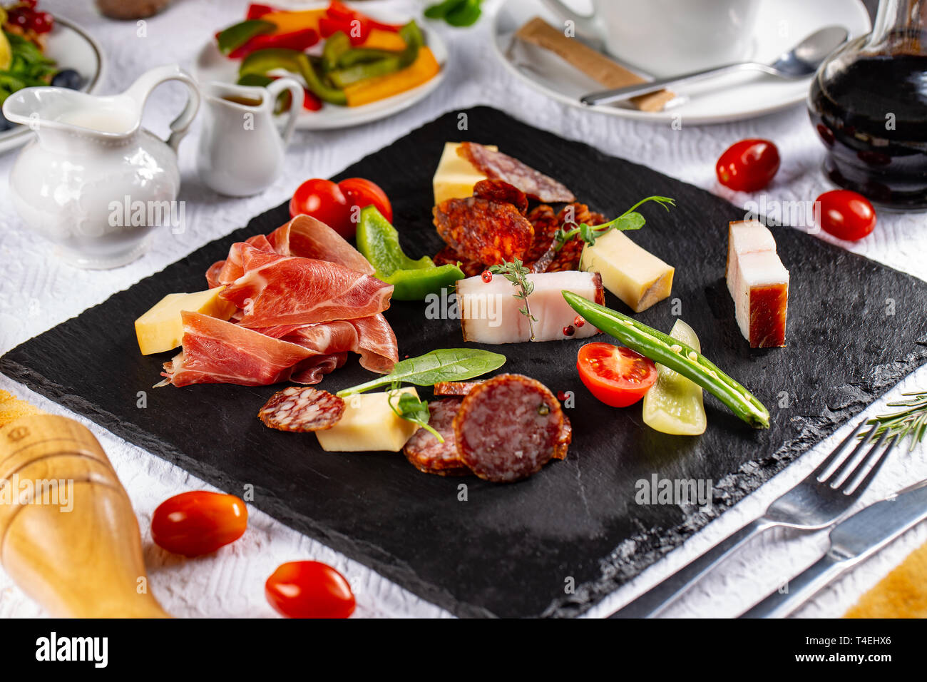 Varietà di salumi, salsicce e bacon servita su una scheda di ardesia presso il ristorante in tabella Foto Stock