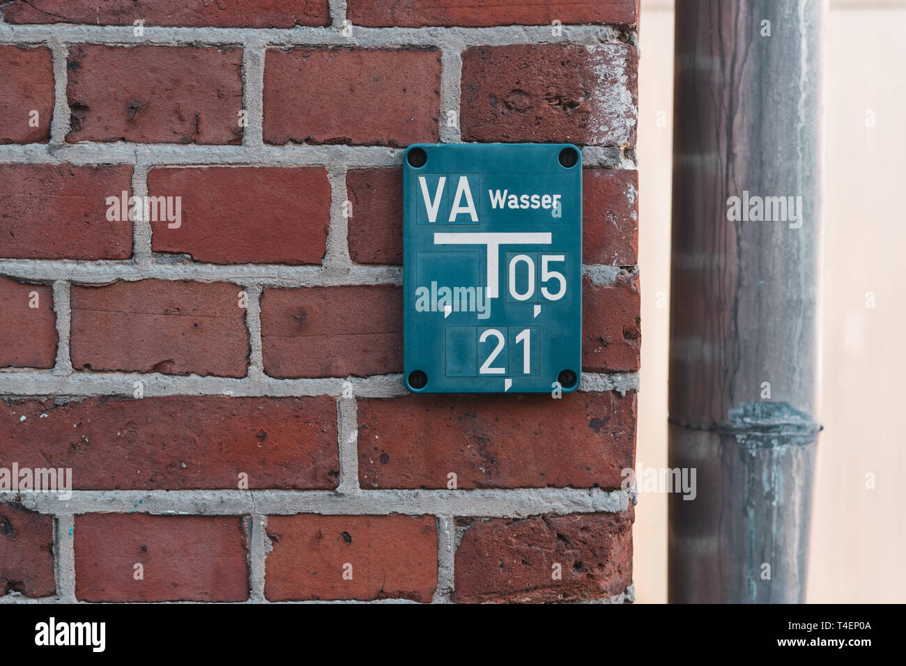 Idrante blu tabella rossa sul muro di mattoni Foto Stock
