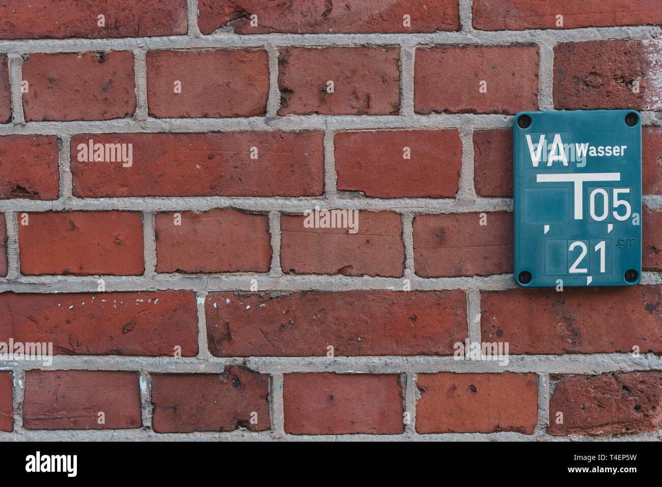 Idrante blu tabella rossa sul muro di mattoni Foto Stock
