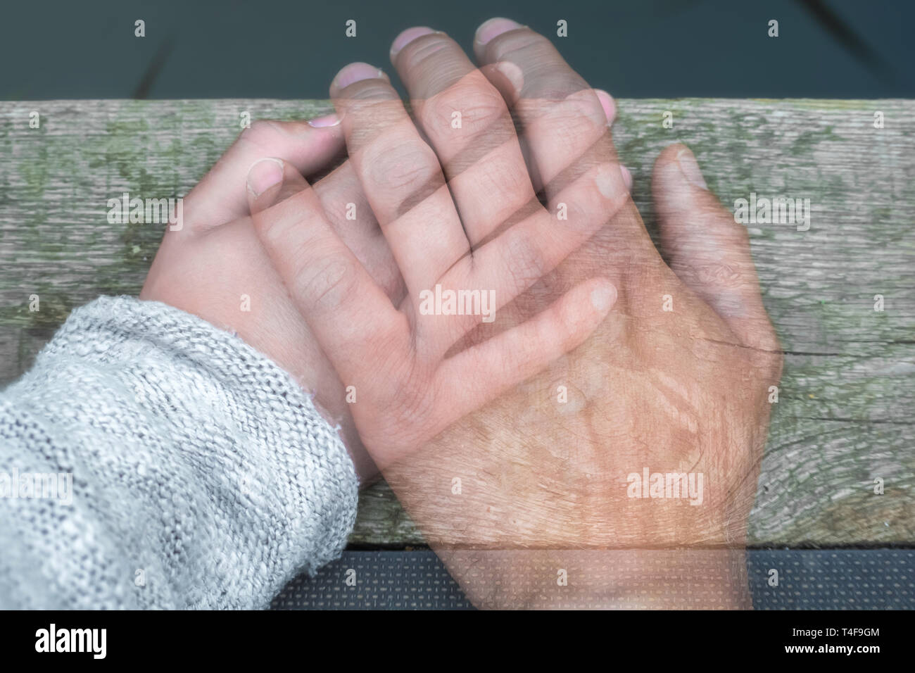 Semi-trasparenti di mano d'uomo su una donna la mano in segno di addio di separazione o morte Foto Stock